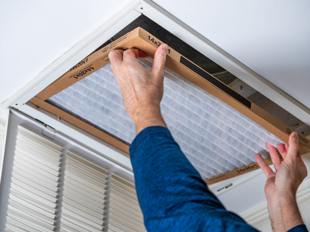 HVAC technician replacing a home air filter in Beverly Hills