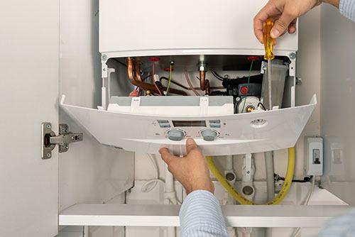 Heating technician repairing a residential boiler in Beverly Hills