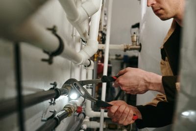 Technician inspecting commercial plumbing pipes in Beverly Hills