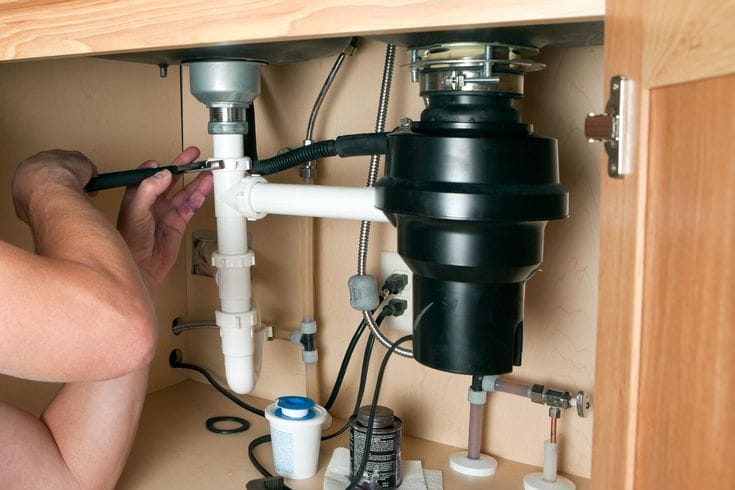 Plumber repairing a garbage disposal in Beverly Hills