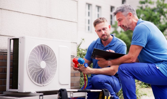 HVAC technicians installing an outdoor air conditioning unit in Beverly Hills