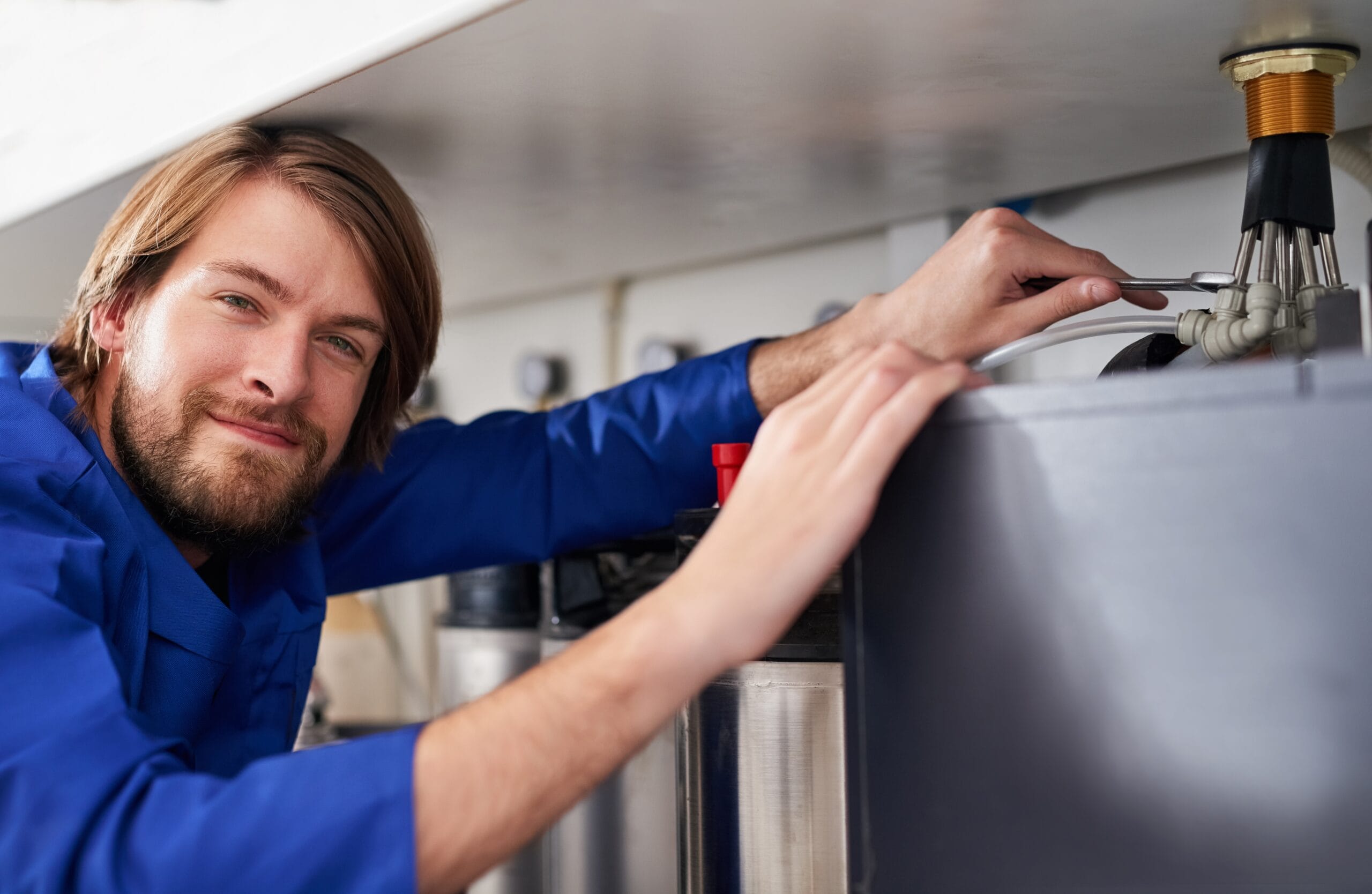 Technician servicing a residential water heater tank in Beverly Hills